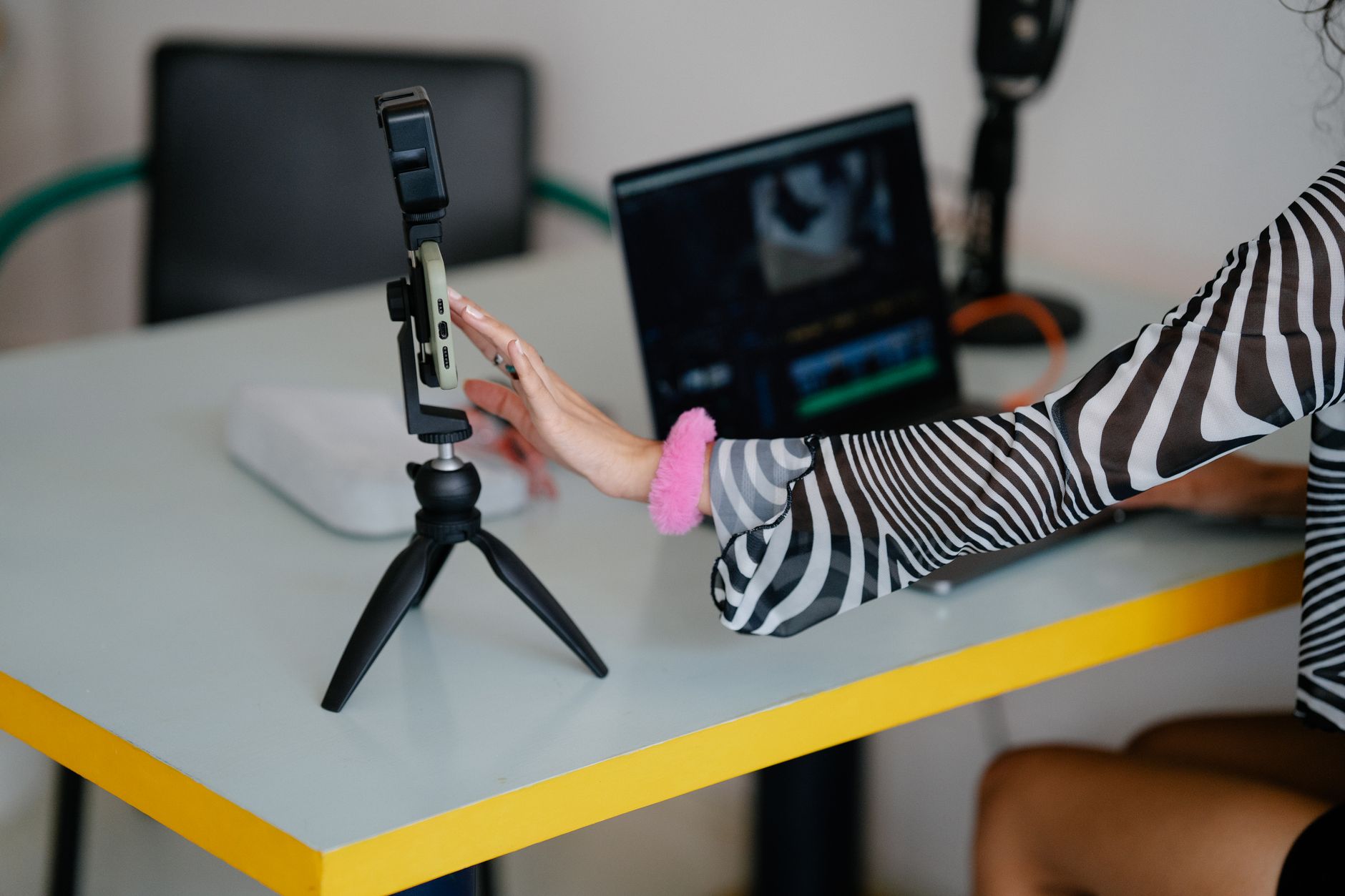 a content creator designing a social media graphic on a laptop in a home studio