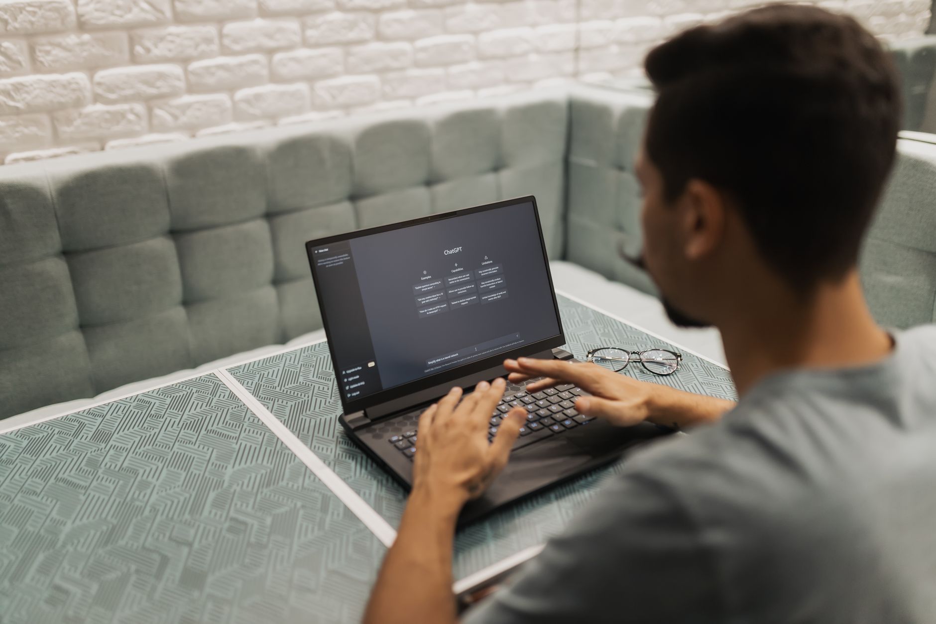 a marketer typing on a laptop with an AI chat interface visible on screen