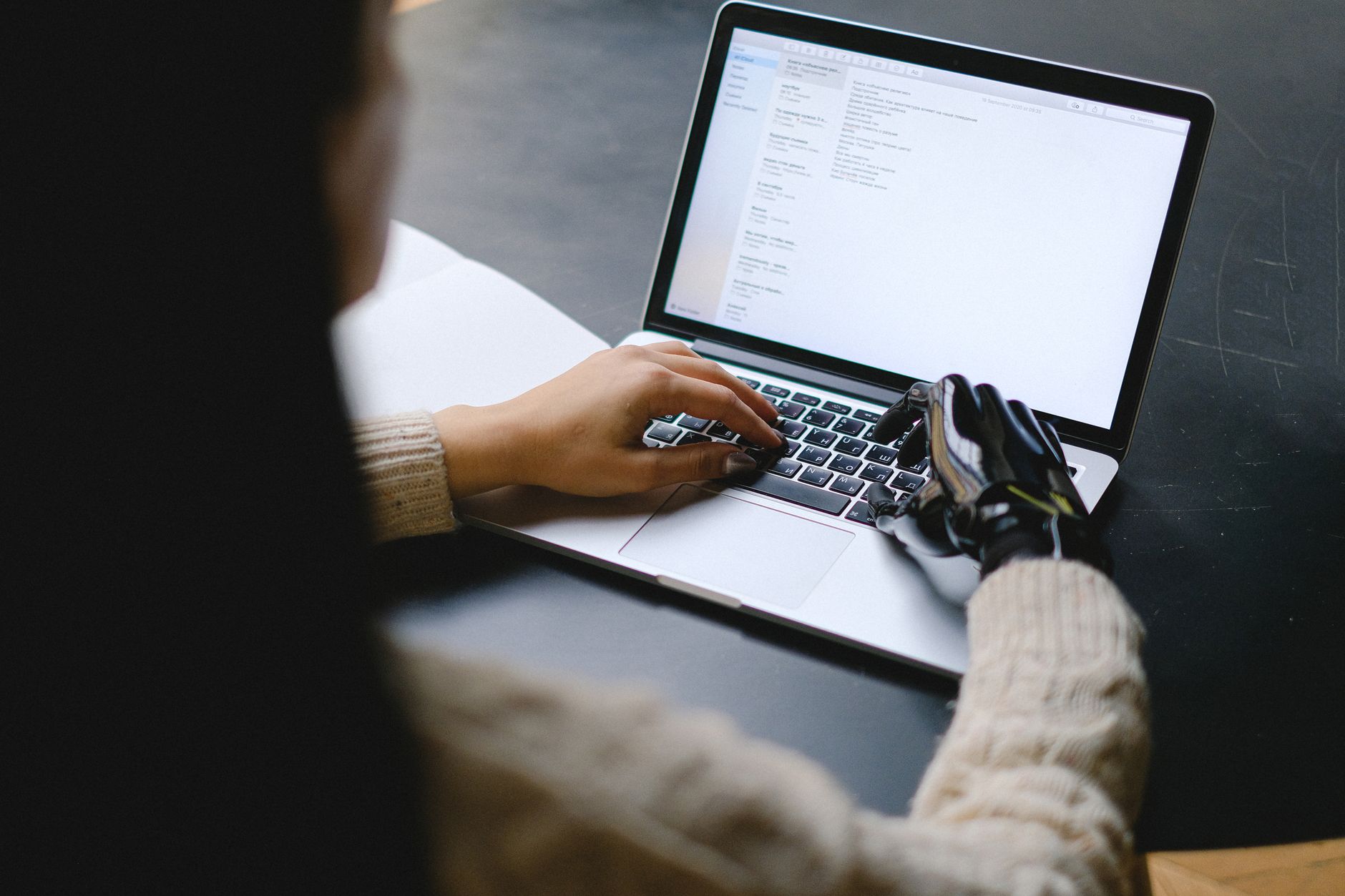 Person typing a resume on a laptop with an AI assistant chat visible