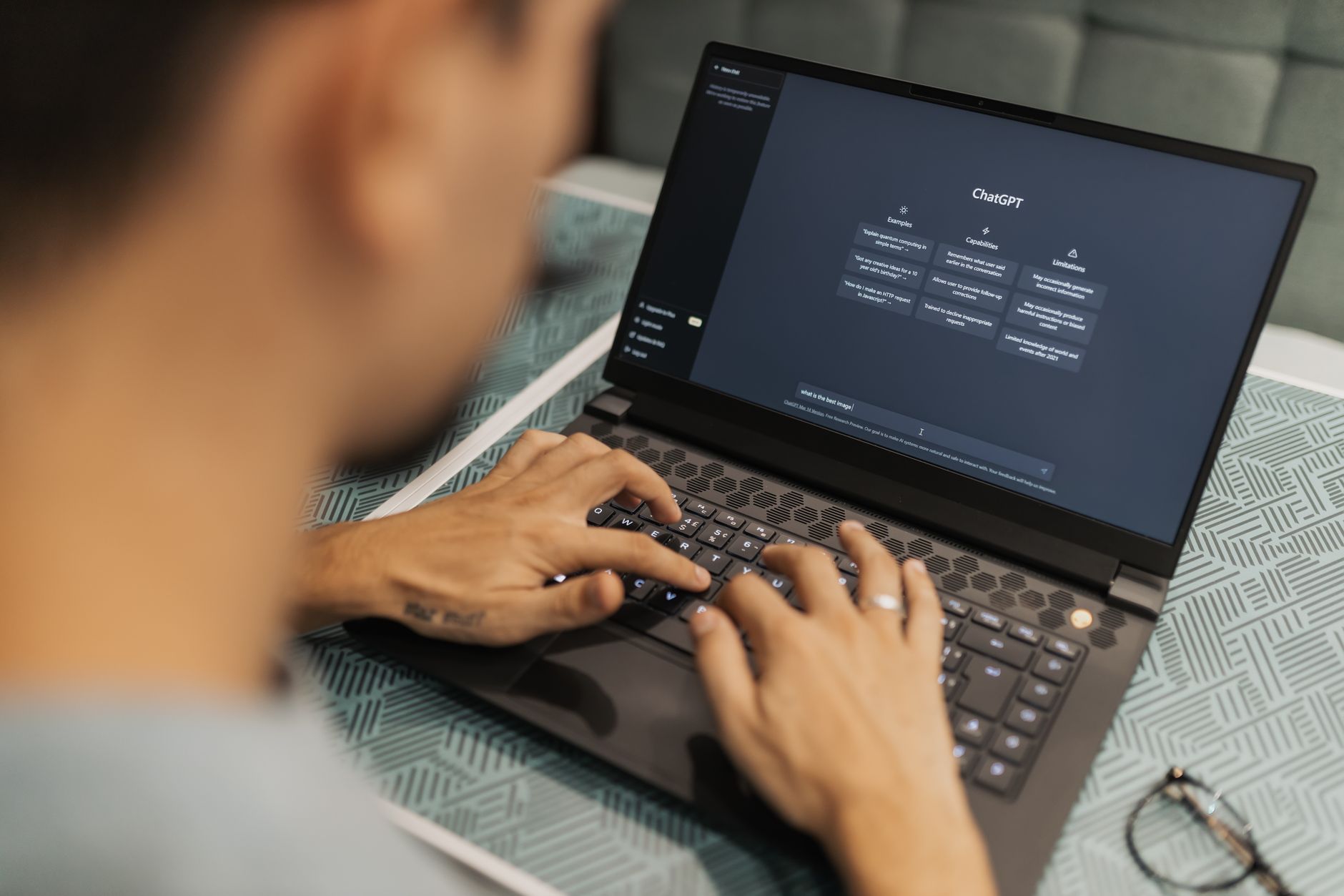 Person typing on a laptop showing an AI chat interface